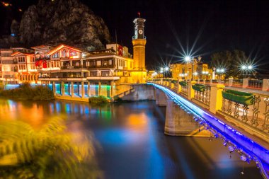 Amasya, Turkey - August, 2017: Old Ottoman houses and Clock Tower with night and mirrored view by the Yesilirmak River in Amasya, Turkey clipart