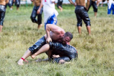 EDIRNE, TURKEY - JULY 14, 2018 : Middle weight wrestlers battle for victory at the Kirkpinar Turkish Oil Wrestling Festival in Turkey.  clipart