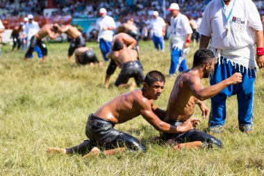 EDIRNE, TURKEY - JULY 14, 2018 : Middle weight wrestlers battle for victory at the Kirkpinar Turkish Oil Wrestling Festival in Turkey.  clipart