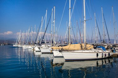 Türkiye 'nin Mugla kentinde, Fethiye kentinde güneşli bir yaz günü turkuaz denizde gemi direkleri ve yansımaları görülüyor. Tatil, Akdeniz ve Ege 'nin en iyi turistik beldesidir..