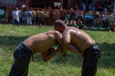 EDIRNE, TURKEY - 14 Temmuz 2018: Türkiye 'de düzenlenen Kırkpınar Türk Yağlı Güreş Festivali' nde orta sıklet güreşçiler zafer için mücadele ediyor. Güreşçi Türkçe demek Pehlivan veya Guresci demek.