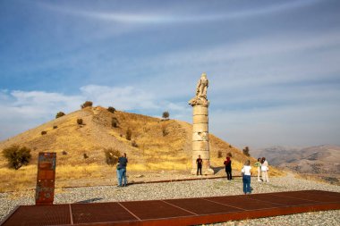 Nemrut, Adiyaman, Türkiye, 12 Ekim 2024: Güneşli bir günde Antik Bir Tepenin Üzerinde Antik Kalıntılar. Bir tepe üzerindeki antik kalıntıları keşfeden insanların görüntüsü seyahat bloglarına uygun güneş ışığıyla yıkanmış.