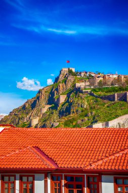 Ankara Şatosu, Ankara 'nın en yüksek yeri. Tepesinde Türk bayrağı, kalenin duvarları, mavi ve bulutlu bir gökyüzü. Turistlerin Ankara, Anadolu ve Türkiye 'yi ziyaret edeceği ünlü bir yer.