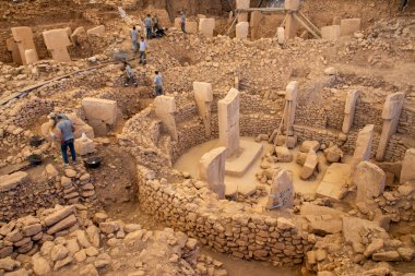 Göbekli Tepe 'de arkeologlar Unear Antik Sırlar. Arkeologlar titizlikle Türkiye 'deki Göbekli Tepe' nin tarih öncesi mekanını kazarak T şeklindeki sütunlar, dairesel duvarlar ve taş duvarları ortaya çıkardılar.