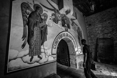 BACHKOVO Manastırı, BULGARIA - 4 Haziran 2019: Manastırın dış avlusunda mumlarla dua edilir. Duvarlarda Bizans yapımı. Renkli çizimler ve İsa, Meryem, azizler ve meleklerin figürleri..