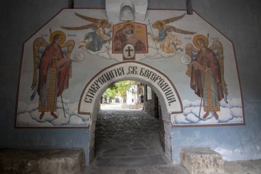BACHKOVO Manastırı, BULGARIA - 4 Haziran 2019: Manastırın dış avlusunda mumlarla dua edilir. Duvarlarda Bizans yapımı. Renkli çizimler ve İsa, Meryem, azizler ve meleklerin figürleri..