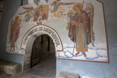 BACHKOVO Manastırı, BULGARIA - 4 Haziran 2019: Manastırın dış avlusunda mumlarla dua edilir. Duvarlarda Bizans yapımı. Renkli çizimler ve İsa, Meryem, azizler ve meleklerin figürleri..
