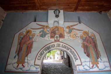 BACHKOVO Manastırı, BULGARIA - 4 Haziran 2019: Manastırın dış avlusunda mumlarla dua edilir. Duvarlarda Bizans yapımı. Renkli çizimler ve İsa, Meryem, azizler ve meleklerin figürleri..