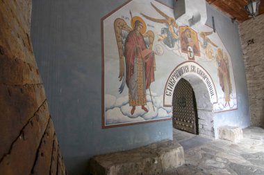BACHKOVO Manastırı, BULGARIA - 4 Haziran 2019: Manastırın dış avlusunda mumlarla dua edilir. Duvarlarda Bizans yapımı. Renkli çizimler ve İsa, Meryem, azizler ve meleklerin figürleri..