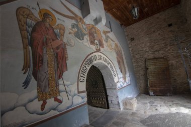 BACHKOVO Manastırı, BULGARIA - 4 Haziran 2019: Manastırın dış avlusunda mumlarla dua edilir. Duvarlarda Bizans yapımı. Renkli çizimler ve İsa, Meryem, azizler ve meleklerin figürleri..