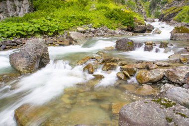 Stones in a stream with water blurred by long exposure