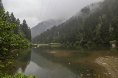 Reflections of mountains and green forest on stormy day on a foggy day landscape. One of the famous tourist spots Black Sea, Trabzon, Turkey. clipart