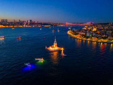İstanbul 'un İstanbul Boğazı' ndaki aydınlık Bakire Kulesi 'nin alacakaranlıktaki hava manzarası. Alacakaranlıkta İstanbul, Türkiye 'deki Bakire Kulesi' nin (Kiz Kulesi) hava görüntüsü. Türkiye seyahati gece romantik turu