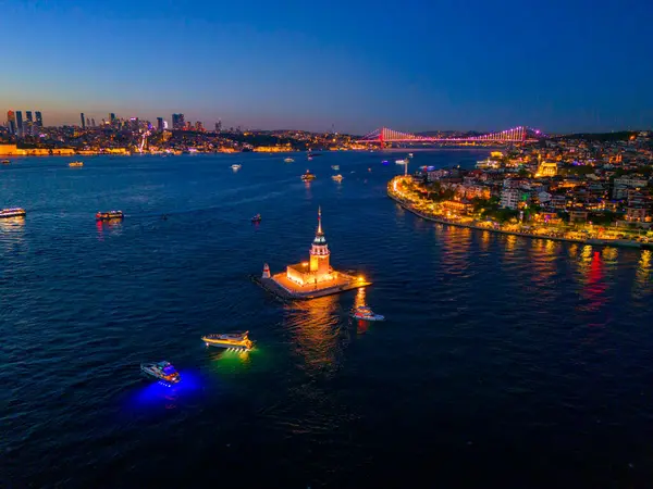 İstanbul 'un İstanbul Boğazı' ndaki aydınlık Bakire Kulesi 'nin alacakaranlıktaki hava manzarası. Alacakaranlıkta İstanbul, Türkiye 'deki Bakire Kulesi' nin (Kiz Kulesi) hava görüntüsü. Türkiye seyahati gece romantik turu
