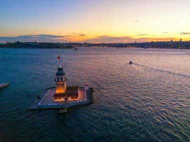 İstanbul 'da Sunset' teki Bakire Kulesi 'nin çarpıcı Kiz Kulesi Hava Görüntüsü. Türkiye 'nin İstanbul kentindeki Maiden Tower' ın güzel bir günbatımında çekilmiş bir fotoğrafı. Bot Boğazı turistik yerleri ziyaret ediyor.
