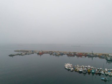 İnsansız hava aracının hava görüntüsü. Yukarıdan manzara. Sisli bir günde liman manzarası. Poyrazkoy İstanbul Türkiyesi Beykoz Poyrazkoy 'da sisli bir günde limana çok sayıda tekne yanaşmış. 