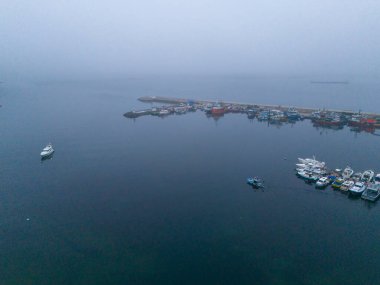 Türkiye 'de tekneli bir hava aracının rıhtımdaki görüntüsü. Sisli bir günde demirli teknelerle dolu bir limanın yüksek açılı görüntüsü. Rıhtım ya da rıhtım boyunca sayısız teknenin bulunduğu bir limanın havadan çekilmiş görüntüsü. Poyrazkoy Beykoz İstanbul Türkiye Anadolu Tarafı