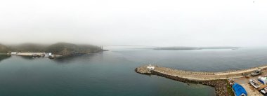 Denizin havadan manzaralı sahili. Güzel deniz hindisi. İskelesi olan sisli bir limanın panoramik manzarası. Liman sahnesinin geniş açılı, panoramik bir görüntüsü. Poyrazkoy Beykoz İstanbul Türk Yavuz Sultan Selim Köprüsü Beykoz sisli Anadolu Tarafı Asya 'nın arkasında