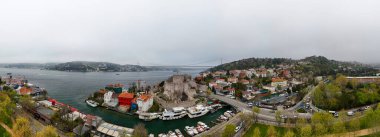 Boğazdan güzel bir panoramik İstanbul şehri. Liman ve tekneli bir sahil kasabasının Beykoz Panoramik manzarası. Yüksek açılı, panoramik manzaralı bir sahil kasabası liman boyunca yerleşmiş. Anadolu Hisari Boğazı Köprüsü Beykoz İstanbul Türkiye güzel