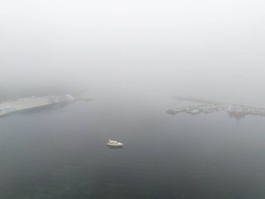 Poyrazkoy Misty Liman Sahnesi Küçük Taşıyıcılı. Sisli bir limanın hava görüntüsü sisli sularda gezinen küçük bir tekneyi gösteriyor. Beykoz İstanbul Türk Yavuz Sultan Selim Köprüsü