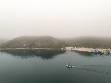 Küçük bir teknesi olan puslu bir liman manzarası. Hafif bir sisle örtülü sakin bir liman sahnesinin havadan görüntüsü. Beykoz Poyrazkoy İstanbul Türkiye Anadolu Tarafı 
