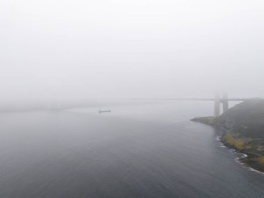Yavuz Sultan Selim Köprüsü Puslu Kıyı Köprüsü Sahnesi Sakin Sulu. Sakin bir su kütlesinin sakin bir hava görüntüsü, muhtemelen bir körfez ya da boğaz, hafif bir sisle örtülü. İstanbul Türkiye Beykoz 