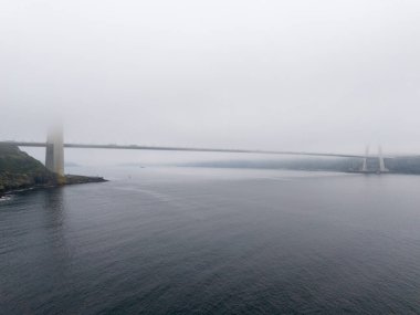 Suyun Üzerindeki Puslu Köprü, Kıyı Sahili. Suya yayılmış bir köprünün sakin, sakin bir görüntüsü, fiyort ya da boğaz olabilir. Yavuz Sultan Selim Köprüsü İstanbul Türkiye Beykoz Poyrazkoy 