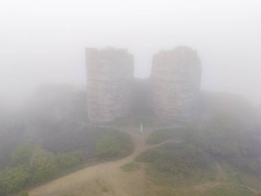 Eski Kuleli Misty Landscape. Kalın bir sis ya da sisin içinde gizlenmiş iki eski taş kulenin havadan görünüşü. Beykoz Yoros Şatosu Anadolu Kavagi İstanbul Türkiye Anadolu 