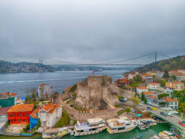 İstanbul 'un tarihi kalesi ve renkli rıhtımının panoramik manzarası. Anadolu Kalesi Fatih Sultan 'a bakan tarihi bir kalenin çarpıcı bir görüntüsü. 
