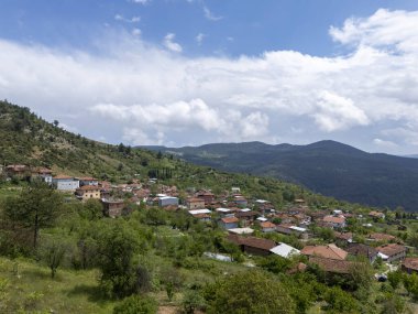 Türkiye 'nin Bursa kentindeki Gelmi manzaralı köy manzarasında, yeşil tepelerde parlak bir gökyüzü altında geleneksel evler bulunuyor. Bu huzurlu kırsal yerleşkeyi çevreleyen yemyeşil manzara ve orman dağları. 