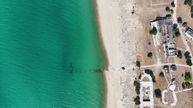 Edirne, Enez 'deki Saros Körfezi kıyılarının 4K hava aracı görüntüsü. Sahildeki terk edilmiş binalar, berrak turkuaz deniz ve el değmemiş kumlu sahil doğa ve tarihin benzersiz bir karşıtlığını yaratır..