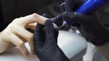 Elektrikli tırnak törpüsü. Güzellik uzmanında çivi eklentisi. Yüksek kalite 4k görüntü