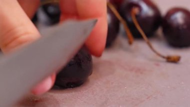 Kadınların elleri tatlı kirazları dilimlerdi. Yüksek kalite 4k görüntü