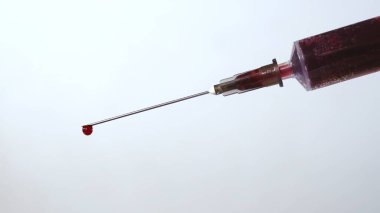 Şırıngadan kan damlıyor. Şırıngadan dökülen kan damlası. Yüksek kalite fotoğraf