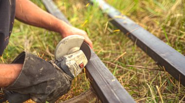 Kıyma makinesiyle metal açı çubuğu kesen adam. Kesme makinesini kullanarak. Yüksek kalite fotoğraf
