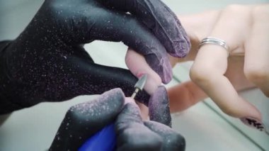 Usta elektrikli tırnak törpüsü kullanarak çivi öğütüyor. Yüksek kalite 4k görüntü