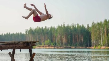 Adam takla atarak suya atladı. Yüksek kalite fotoğraf