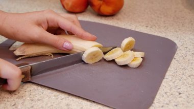 Kadınların elleri bir muzu dilimler. Yüksek kalite fotoğraf