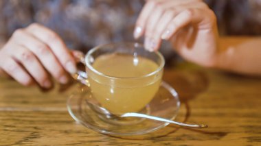 Bardaklı kız bir fincan çayın üzerinde parmaklarını ovuyor. Yüksek kalite fotoğraf