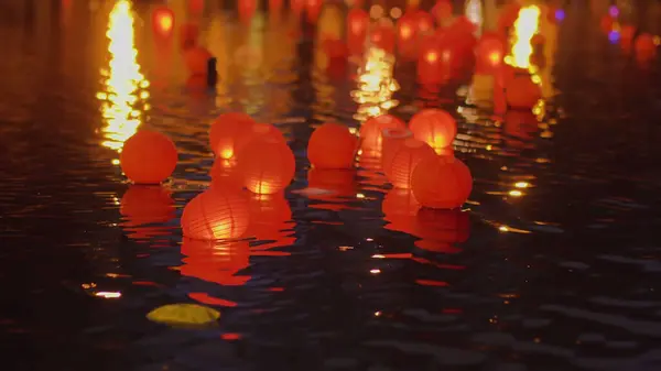 Floating red candles lanterns on the water at night. High quality photo