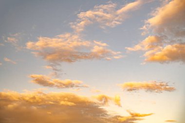 Sarı günbatımı ışığı gökyüzüne sahip beyaz bulutlar. Yüksek kalite fotoğraf