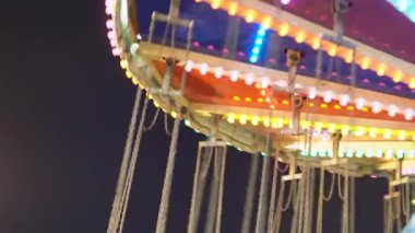 Gece gökyüzünde yuvarlak atlıkarınca ışıkları. Yüksek kaliteli video