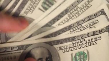 Bir adamın elinde yüz dolarlık banknotlar. Yüksek kaliteli video
