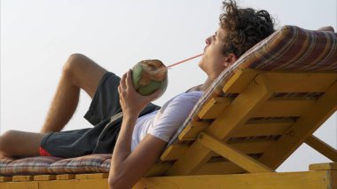 Adam bankta rahatlıyor ve içiyor. Yüksek kalite fotoğraf