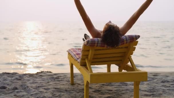 Χαρούμενος Άνθρωπος Κάνει Ηλιοθεραπεία Μια Σεζλόνγκ Στην Παραλία Υψηλής Ποιότητας — Αρχείο Βίντεο