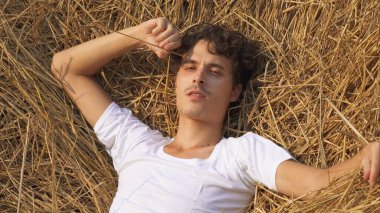 Erkek model samanlıkta yatıyor. Yüksek kalite fotoğraf