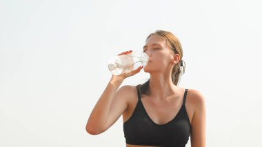 Spor eğitiminde su şişesinden su içen atletik bir kız. Yüksek kalite fotoğraf