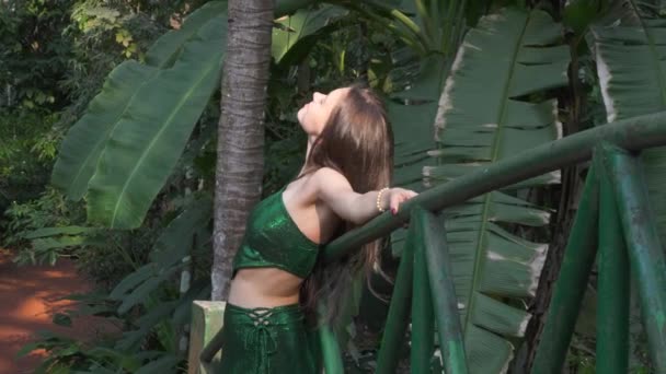 若い女性はジャングルを背景に橋の上に立っている 高品質の4K映像 — ストック動画