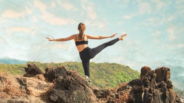 Utthita Hasta Padangusthasana 'yı parkta yapan genç bir kadın. Yüksek kalite fotoğraf