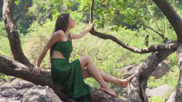 Junge Frau Sitzt Auf Einem Baum Einem Grünen Kleid Dschungel — Stockvideo